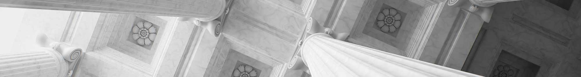 looking up at the carved ceiling of a large building with marble columns